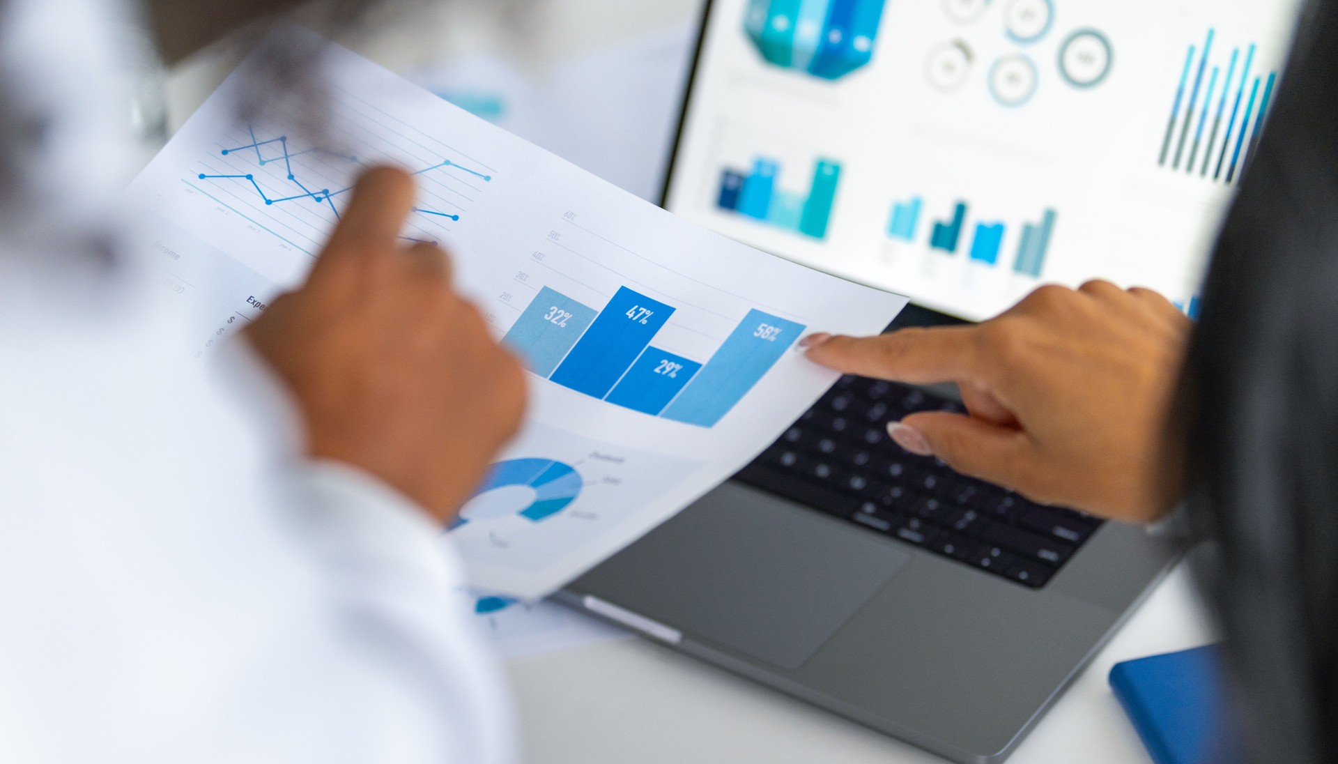Group of business women working on a financial data document.